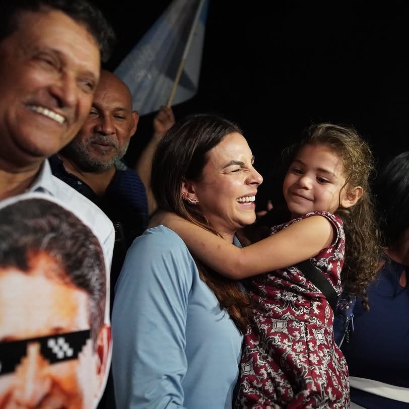 No colo, o abraço de uma criança em ato de campanha
